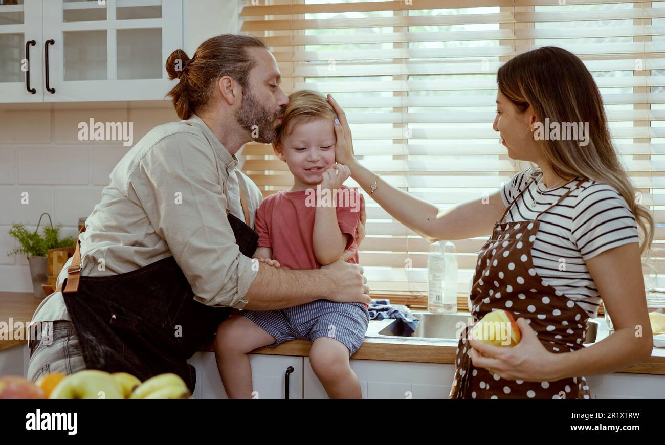 Glückliche Familie, die Obst in der Küche isst. Stockfoto