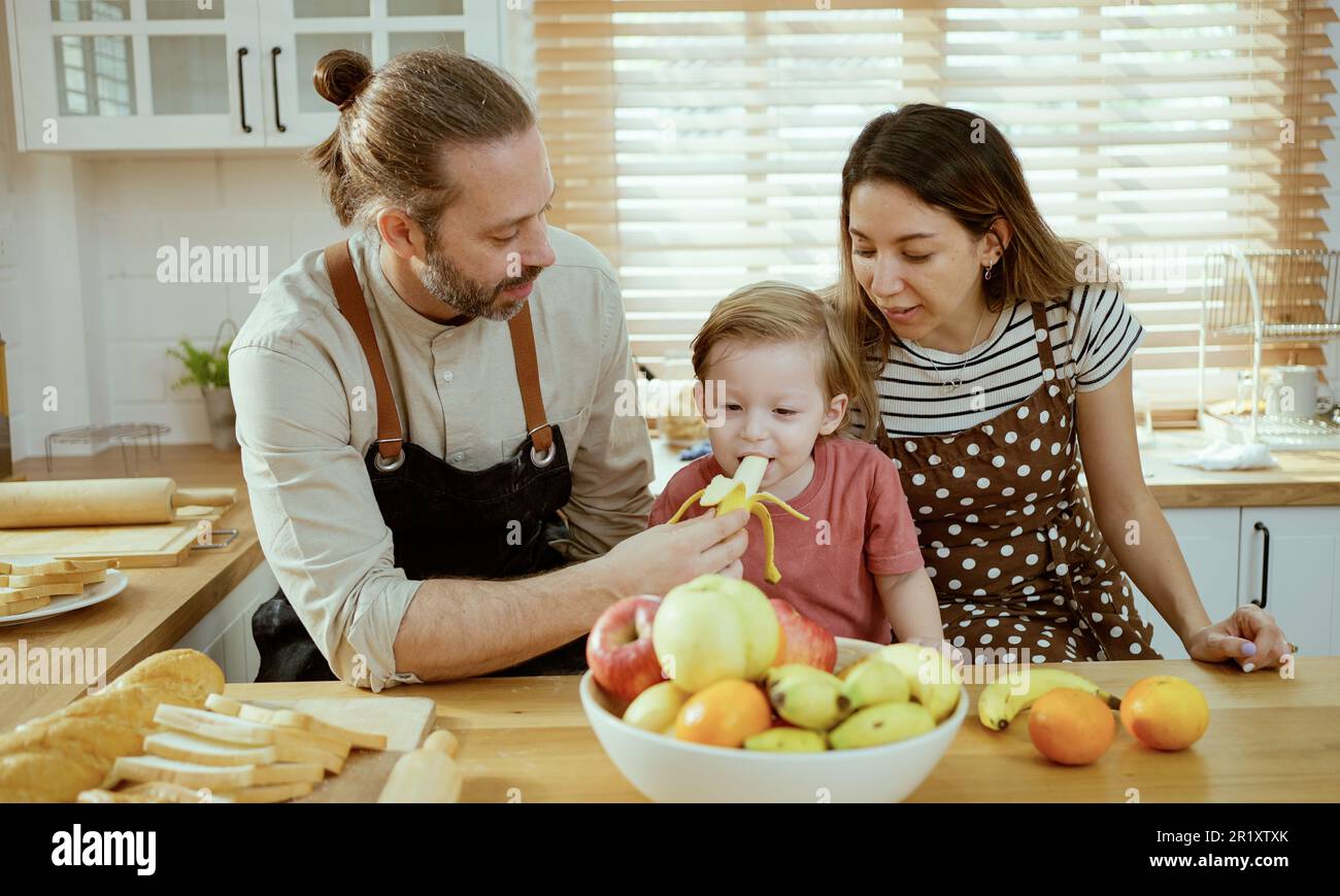 Glückliche Familie, die Obst in der Küche isst. Stockfoto
