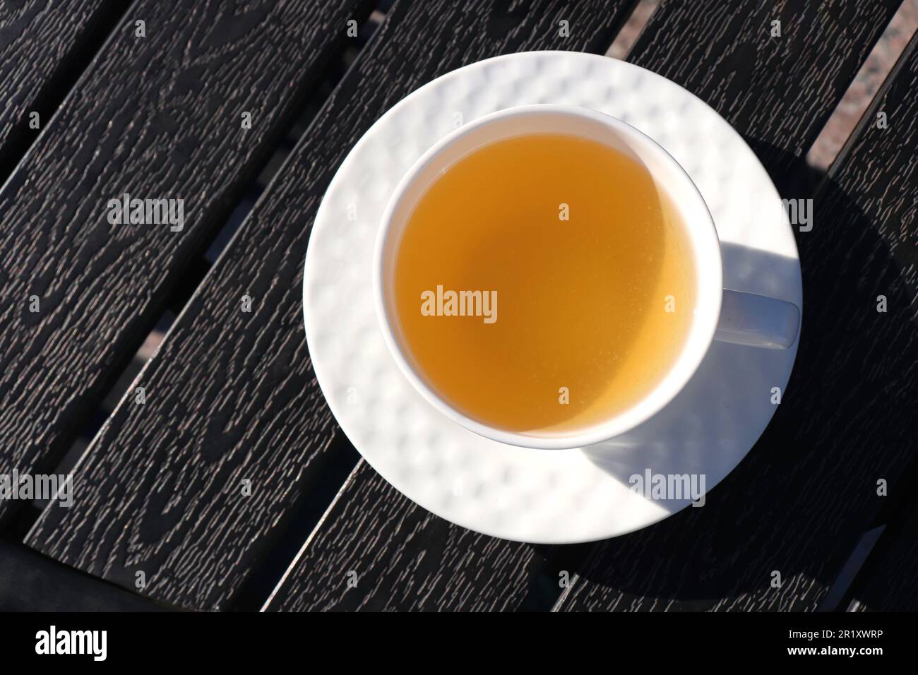 Eine Tasse grünen Tee auf schwarzem Holzhintergrund. Reinigung oder Entgiftung Tee ist eine gute Möglichkeit zur Gewichtsabnahme. Antioxidative Eigenschaften. Speicherplatz kopieren. Gesund Stockfoto