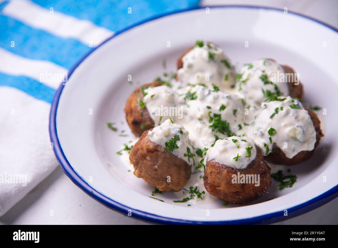 Griechische Fleischbällchen mit Joghurt-Sauce. Ein Fleischklößchen ist ...