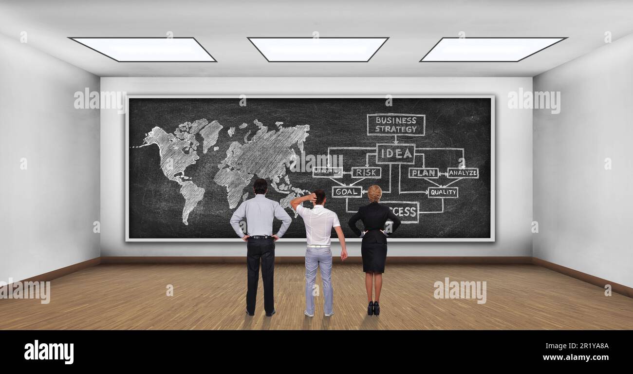 Drei Geschäftsleute, die an die Tafel schauen, mit einem Geschäftsplan und einer Weltkarte Stockfoto
