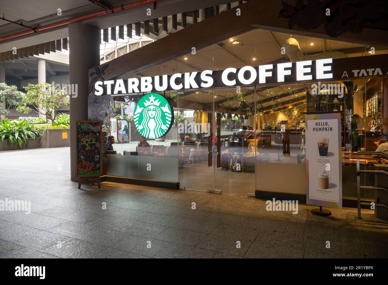MUMBAI - 20. SEPTEMBER: Starbucks Coffee mit Logo am Eingang und Besucher in Mumbai am 20. September. 2022 in Indien Stockfoto