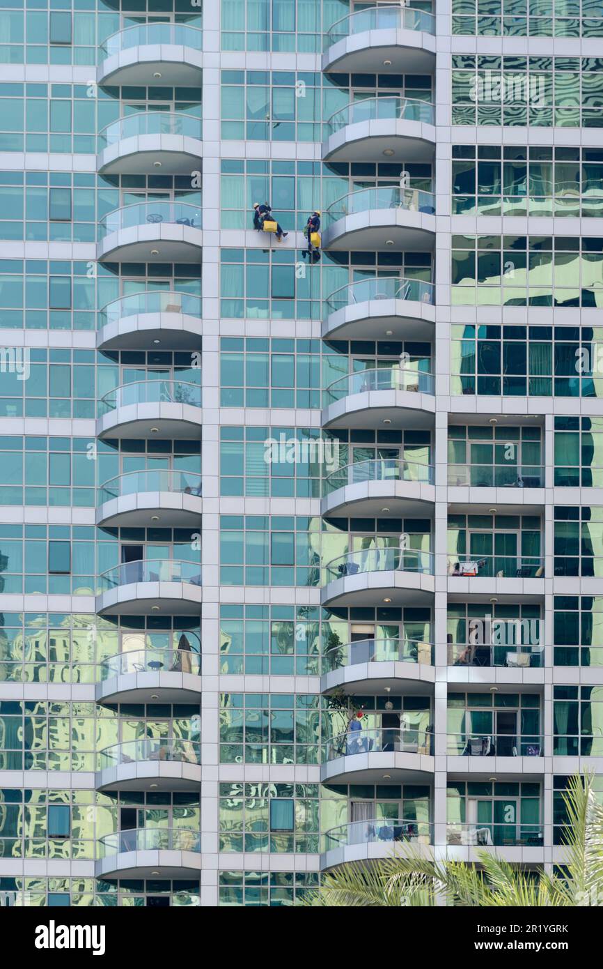 Fensterputzer Seilen sich in einem Wolkenkratzer in Dubai Marina, Dubai, Vereinigte Arabische Emirate ab Stockfoto