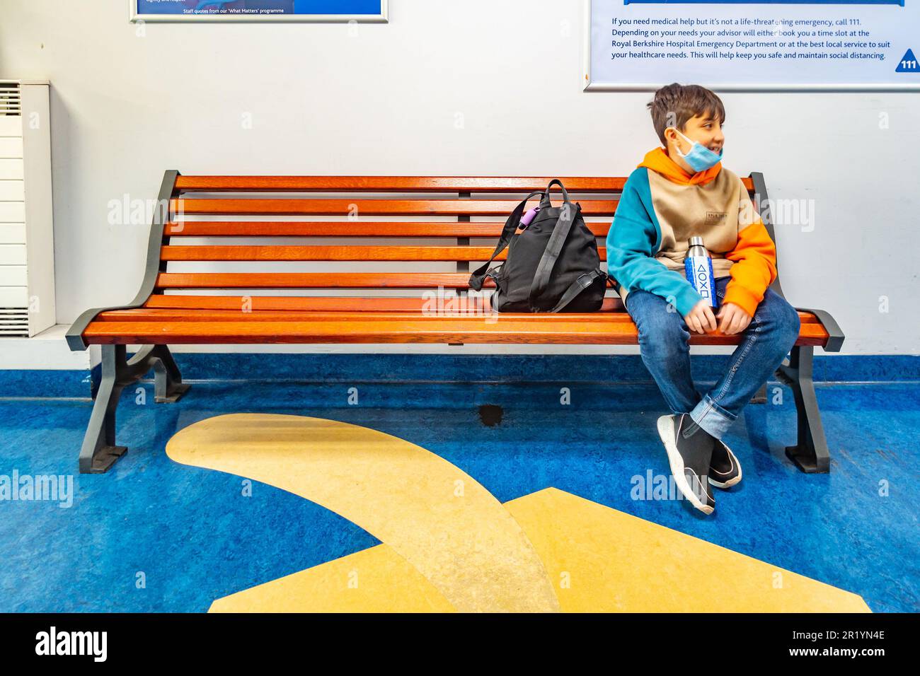 Ein Junge saß auf einer Bank in einem Wartebereich Stockfoto