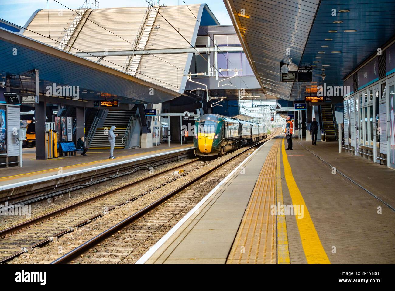 Ein GWR-Zug kommt am Bahnsteig am Bahnhof Reading in Berkshire, Großbritannien an, während die Passagiere auf die Ankunft warten Stockfoto