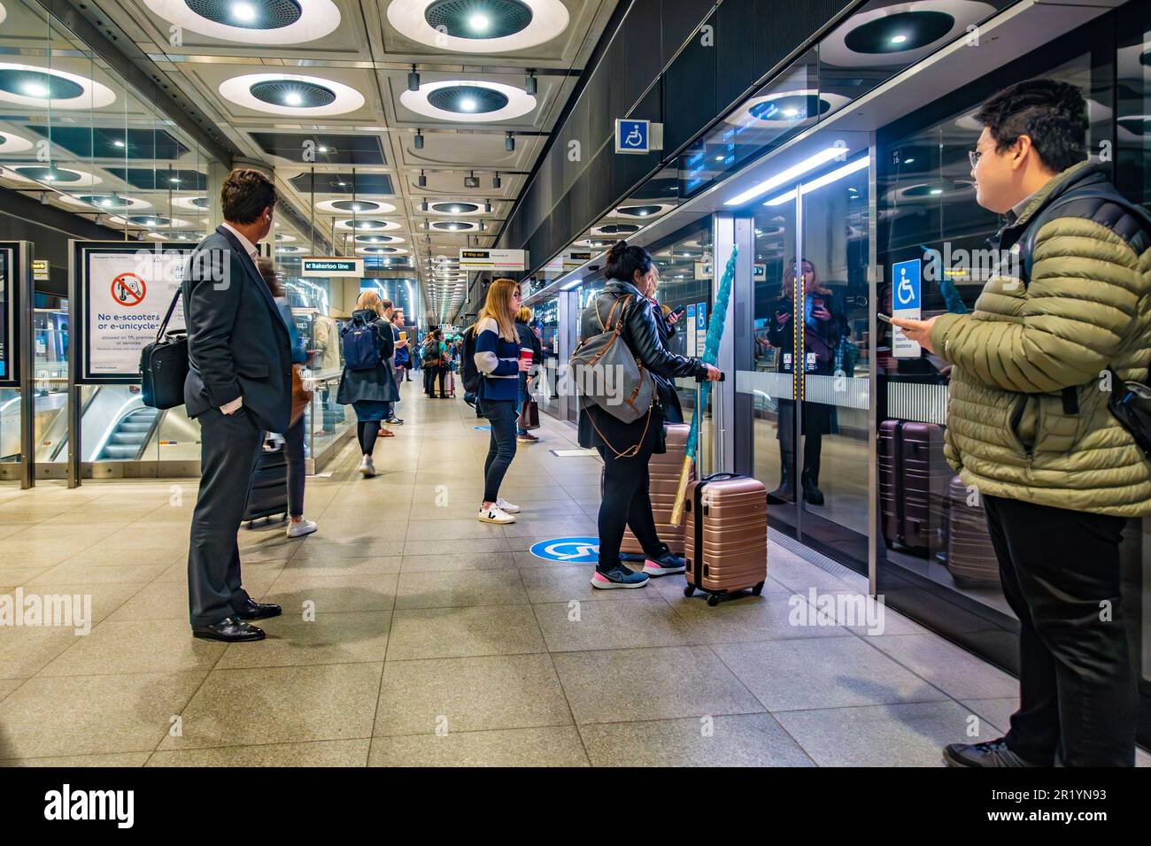Die Leute stehen an und warten auf einen Elizabeth Line London U-Bahn Zug an der Paddington Station Stockfoto