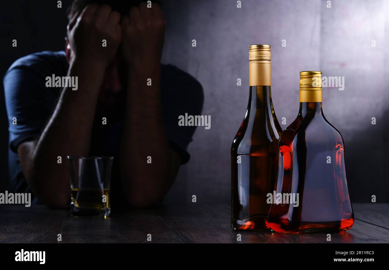 Flaschen mit alkoholischen Getränken und die Abbildung von einem betrunkenen Mann Stockfoto
