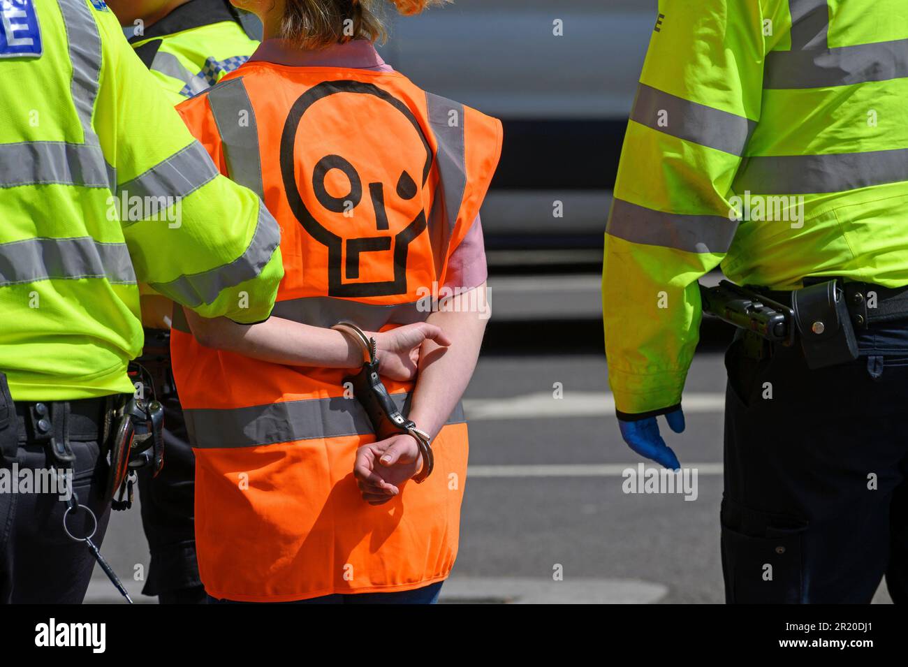 Junge Frau, die während eines Just Stop Oil-Protests am Parliament Square im Zentrum von London am 3. Mai 2023 in festen Handschellen festgenommen wurde. Stockfoto