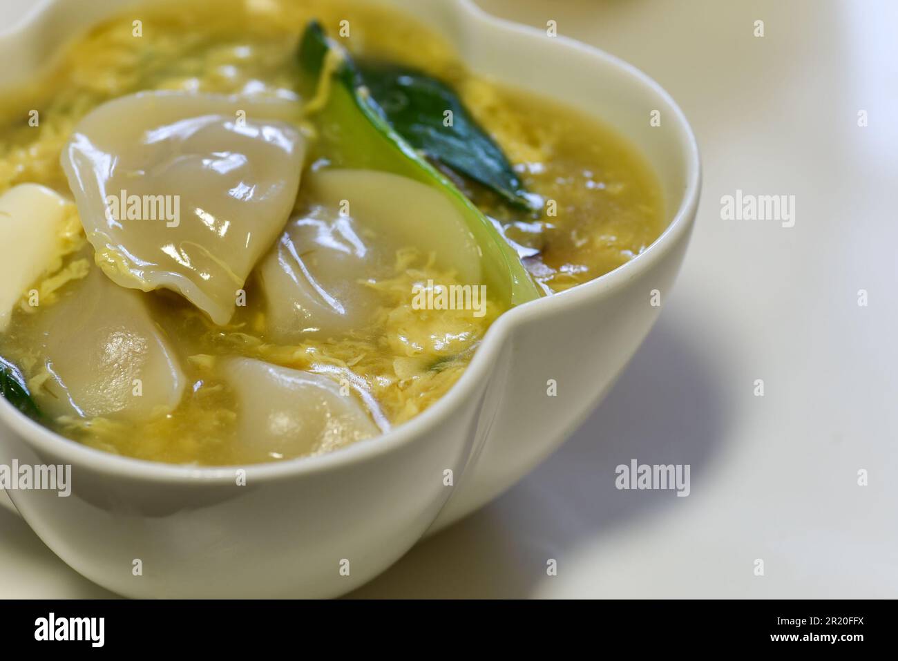 Chinesische Eiersuppe mit Teigtaschen, Tofu und Kohlgemüse Stockfoto