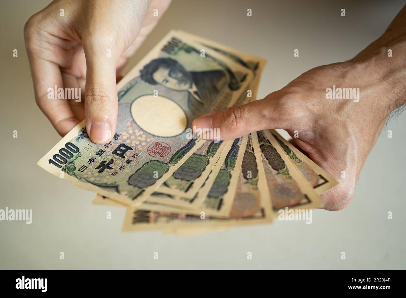 Männer halten 1000 japanische Yen-Banknoten in der Hand Stockfoto