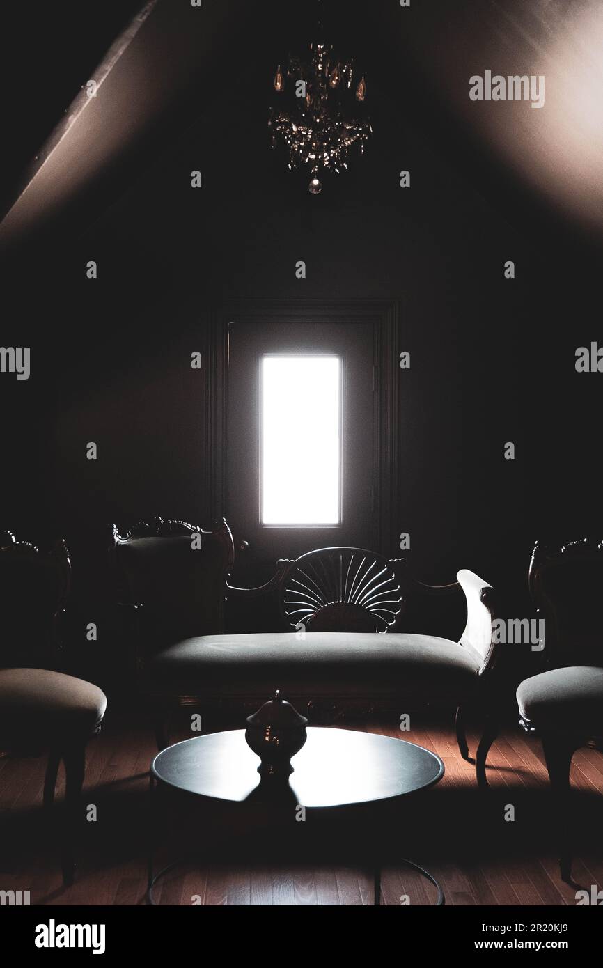 Ein Wohnzimmer mit einem schwarzen, rechteckigen Sofa und zwei passenden Sesseln Stockfoto