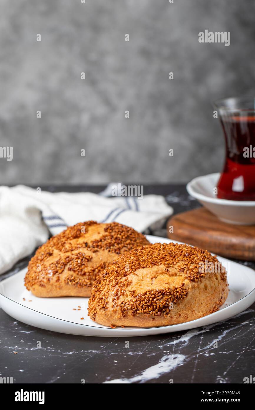 Sesam- und Käsegebäck auf dunklem Hintergrund. Türkisches Straßenessen. Peynirli pogaca Stockfoto