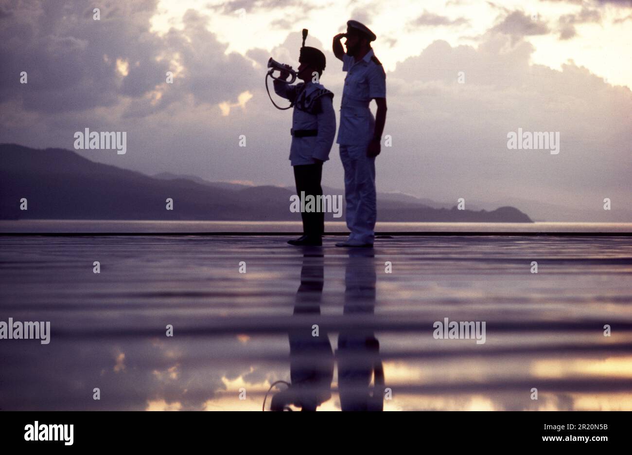HMS Unbesiegbarer Salut bei Sonnenuntergang, 1984 Stockfoto