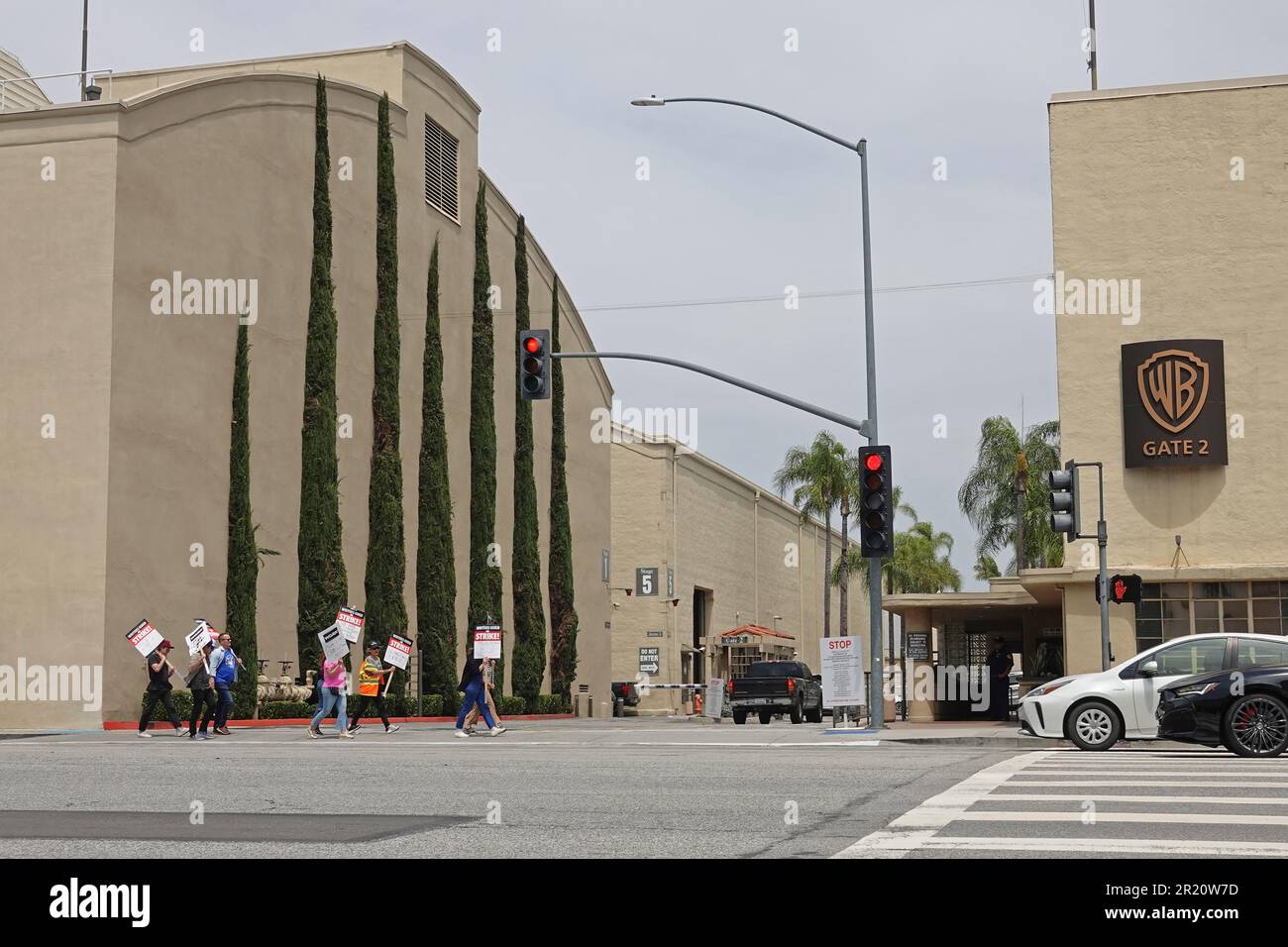 Burbank, Kalifornien/USA - 15. Mai 2023: Writers Guild of America WGA-Mitglieder im Streik tragen beim Überqueren der Straße vor dem Streik Streikschilder mit sich Stockfoto