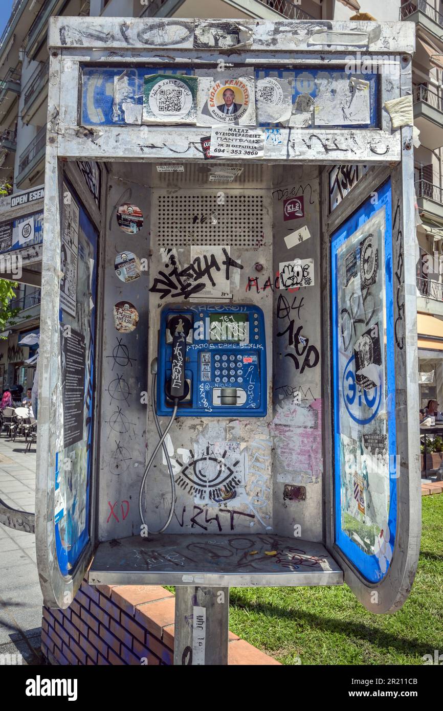 Thessaloniki, Griechenland, 27. April 2023: Öffentliche Telefonzelle mit Aufklebern und Farbklecks im Stadtzentrum von Thessaloniki an einem sonnigen Tag Stockfoto