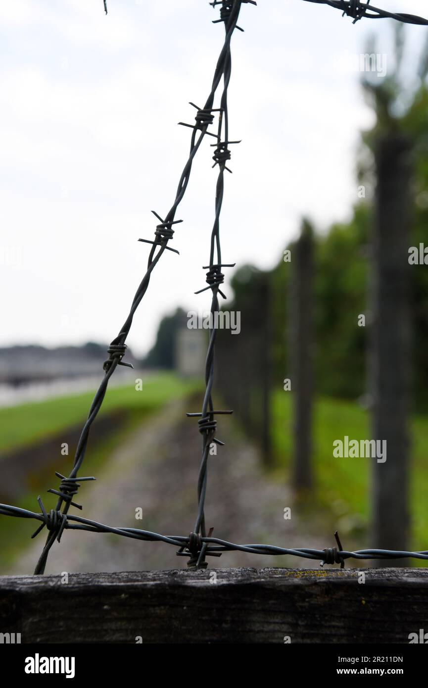 Foto des Stacheldrahts, der den Umzaun des Konzentrationslagers Dachau umgibt. Das Lager war das erste der 1933 eröffneten Konzentrationslager der Nazis. Die ursprüngliche Absicht des Lagers bestand darin, politische Gefangene festzuhalten. Stockfoto