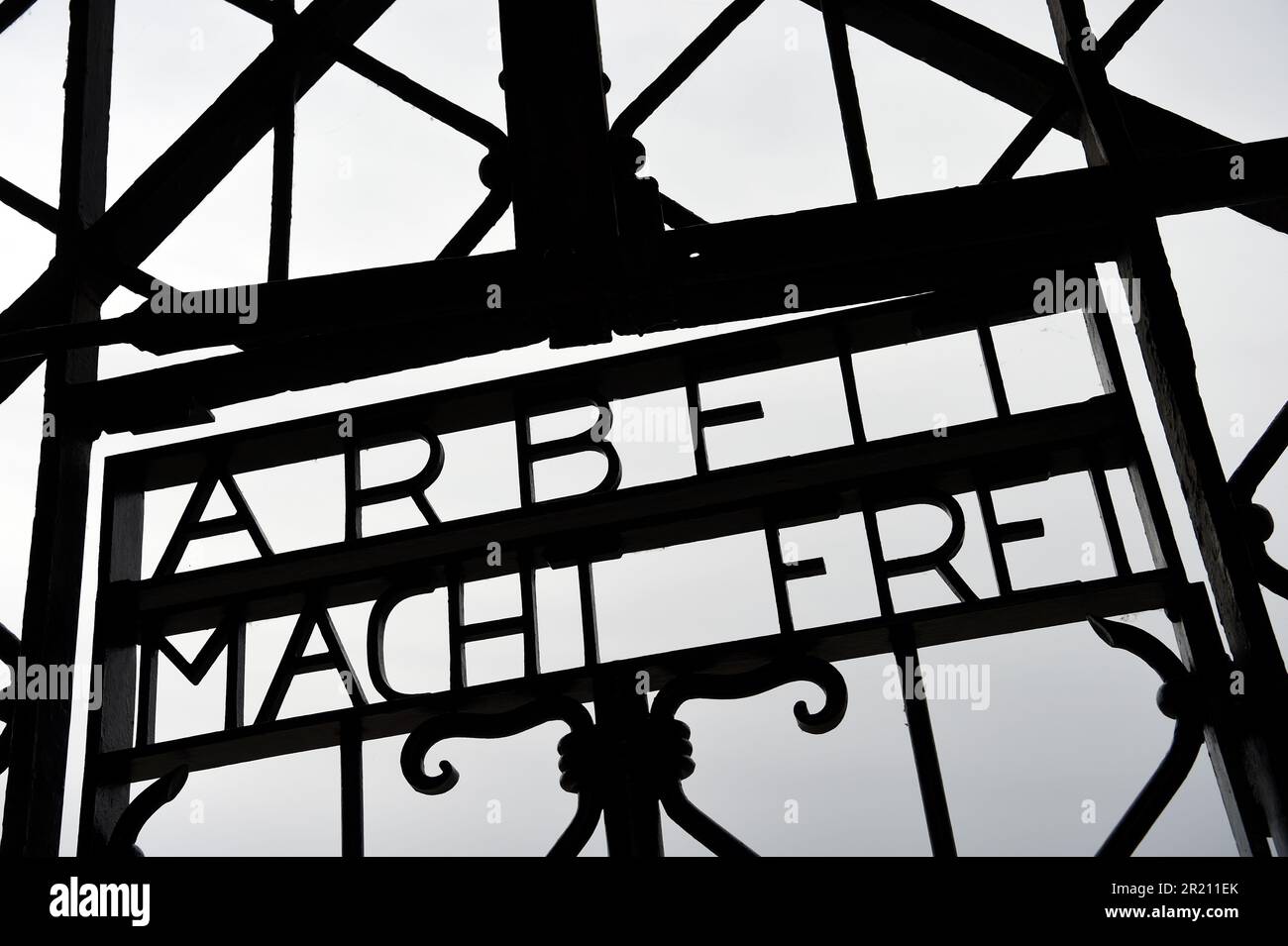 Foto des Slogans "Arbeit macht frei" am Eingang zum KZ Dachau. Der deutsche Ausdruck bedeutet „Arbeit macht Sie frei“. Das Lager war das erste der 1933 eröffneten Konzentrationslager der Nazis. Die ursprüngliche Absicht des Lagers bestand darin, politische Gefangene festzuhalten. Stockfoto