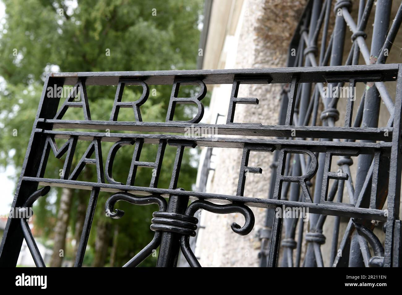 Foto des Slogans "Arbeit macht frei" am Eingang zum KZ Dachau. Der deutsche Ausdruck bedeutet „Arbeit macht Sie frei“. Das Lager war das erste der 1933 eröffneten Konzentrationslager der Nazis. Die ursprüngliche Absicht des Lagers bestand darin, politische Gefangene festzuhalten. Stockfoto