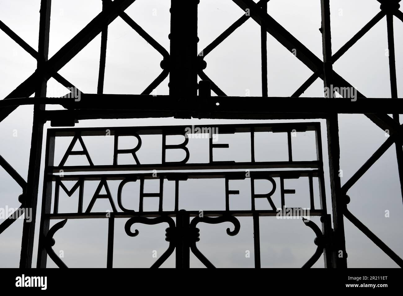 Foto des Slogans "Arbeit macht frei" am Eingang zum KZ Dachau. Der deutsche Ausdruck bedeutet „Arbeit macht Sie frei“. Das Lager war das erste der 1933 eröffneten Konzentrationslager der Nazis. Die ursprüngliche Absicht des Lagers bestand darin, politische Gefangene festzuhalten. Stockfoto