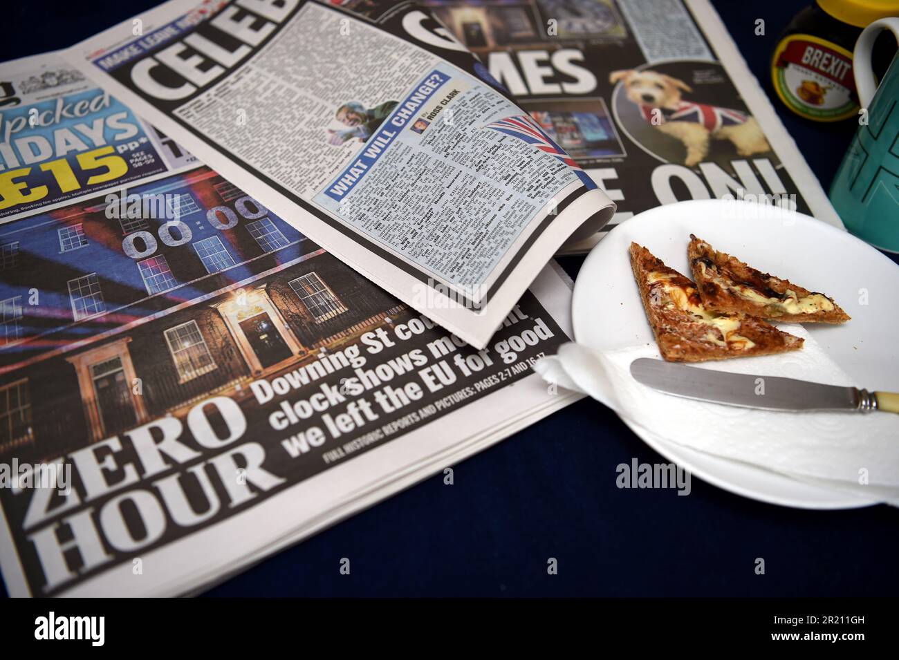 Foto eines Brexit-Frühstücks, einschließlich Zeitung, Union-Jack-Tasse Tee und Toast mit Brexit-Marmite. Stockfoto