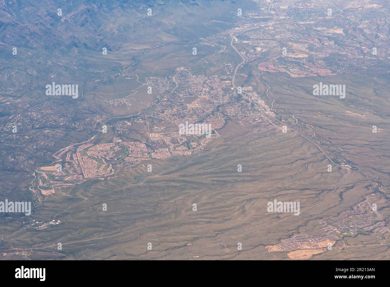 Blick aus der Vogelperspektive auf eingezäunte Gemeinden, Bauvorhaben, Autobahnen und Unterteilungen in der Wüste außerhalb von Los Angeles in Südkalifornien Stockfoto