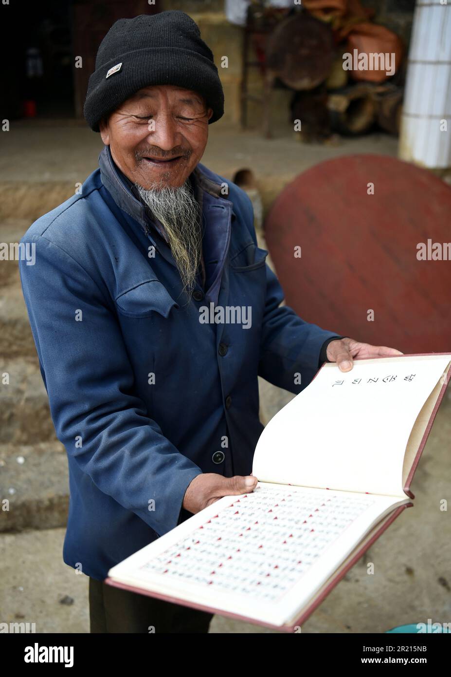 Last of the Pula - einer der ältesten Bewohner des Dorfes Pi Po liest Rituale, die in einer Sprache geschrieben wurden, die bald zu einer vergessenen Sprache des Pula werden könnte, die in dem Dorf östlich von Kaiyuan in der autonomen Präfektur Hani und Yi Honghe, Provinz Yunnan, SW China - das Dorf ist die Heimat der Pula, einer Unterminderheit der Yi- oder Lolo-Bevölkerung, einer ethnischen Gruppe in China, Vietnam und Thailand. Mit 8 Millionen sind sie die siebtgrößte der 55 ethnischen Minderheiten. Stockfoto