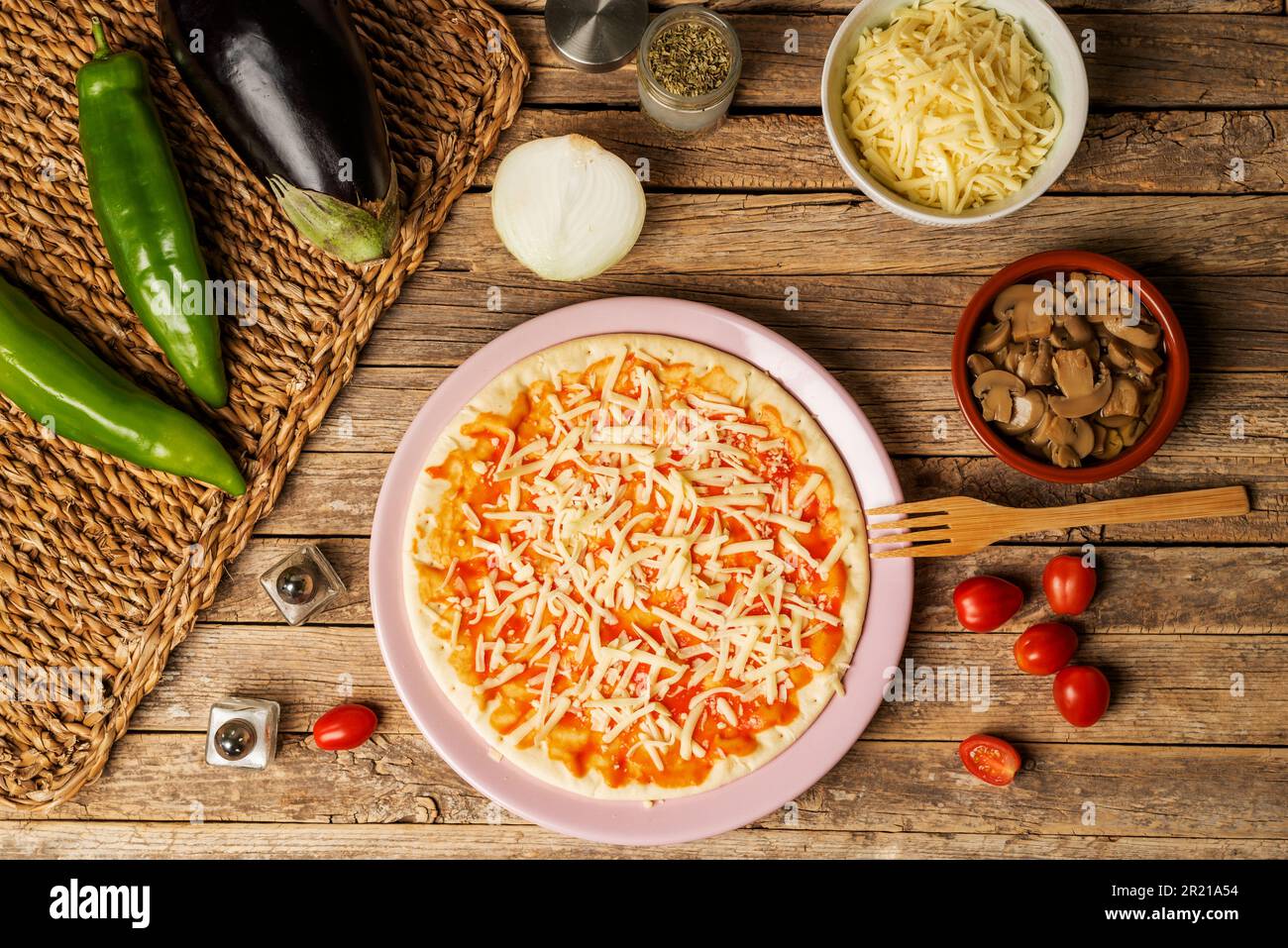 Pizza-Pfanne mit Tomaten und Mozzarella für Veganer, neben Gemüse zum Kochen einer vegetarischen Pizza. Stockfoto