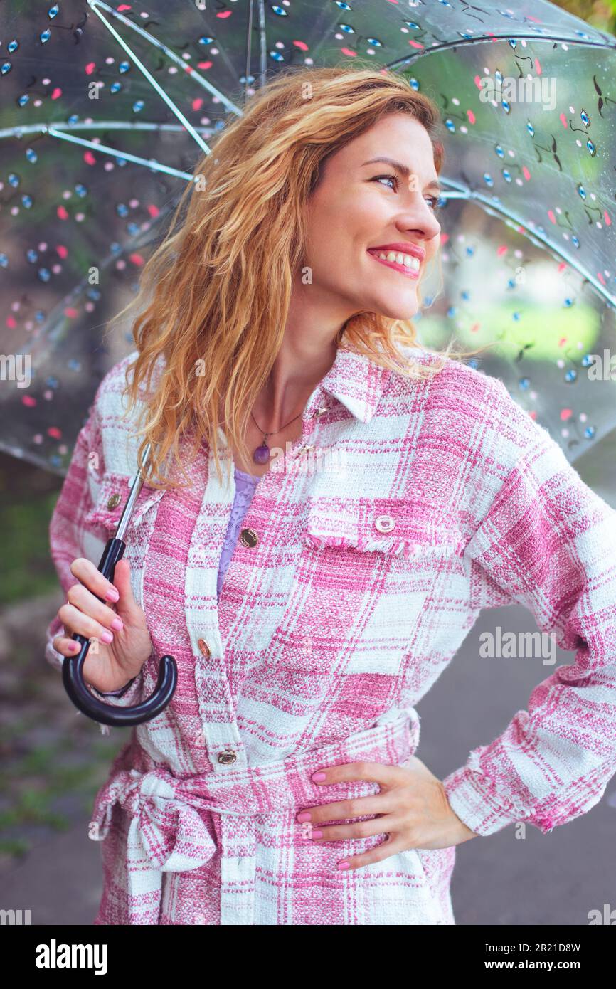 Glückliche rothaarige Weiße im Frühling mit Schirm Stockfoto