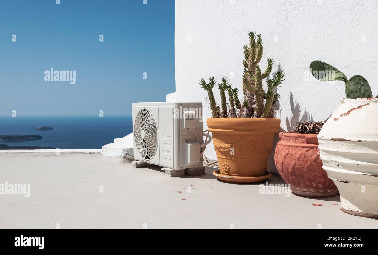 Klimaanlage oder Wärmepumpenanlage in der Nähe von Topfpflanzen in Santorin, Griechenland. Stockfoto