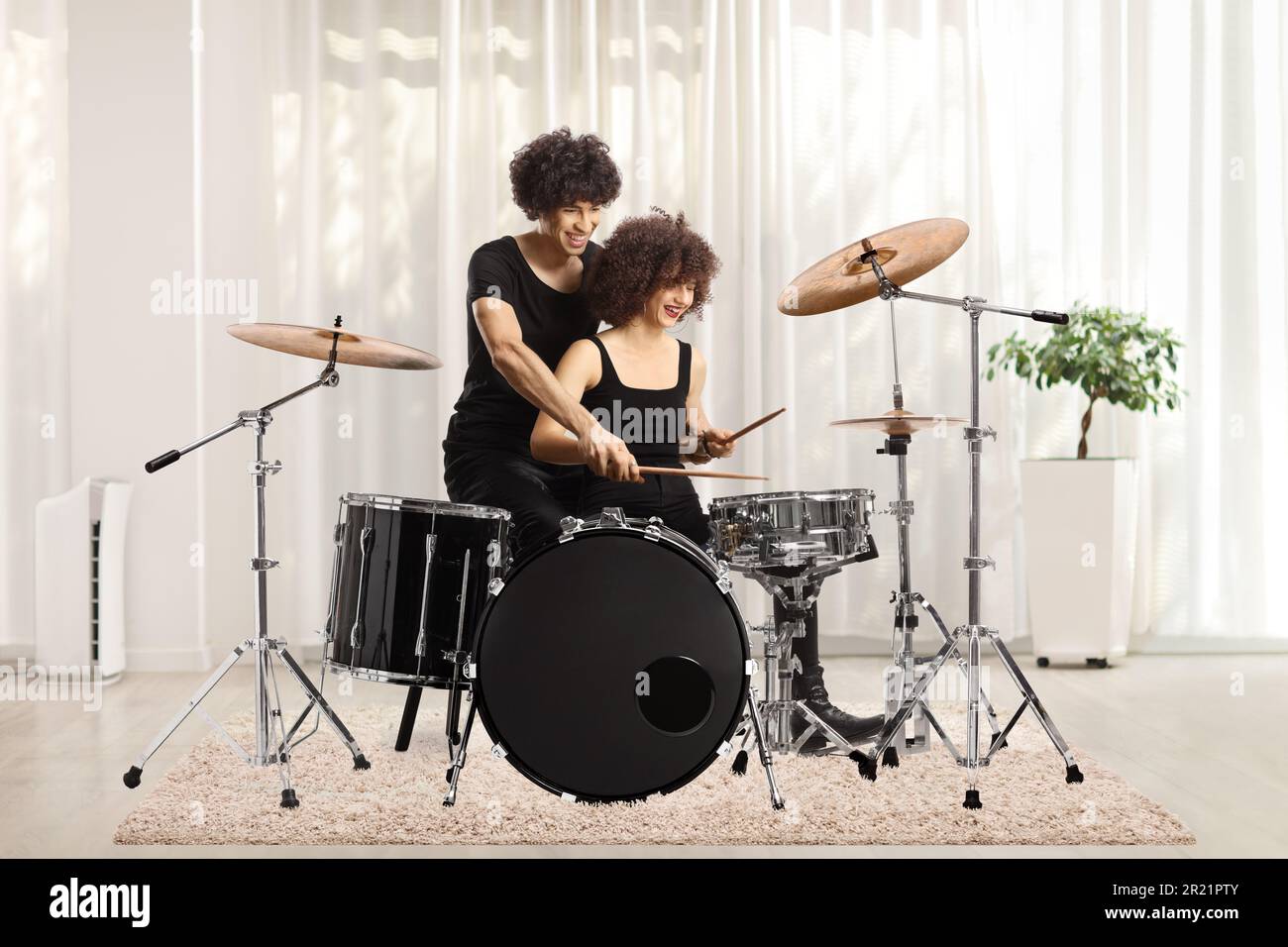 Junger Mann und Frau, die zu Hause Trommeln spielen Stockfoto