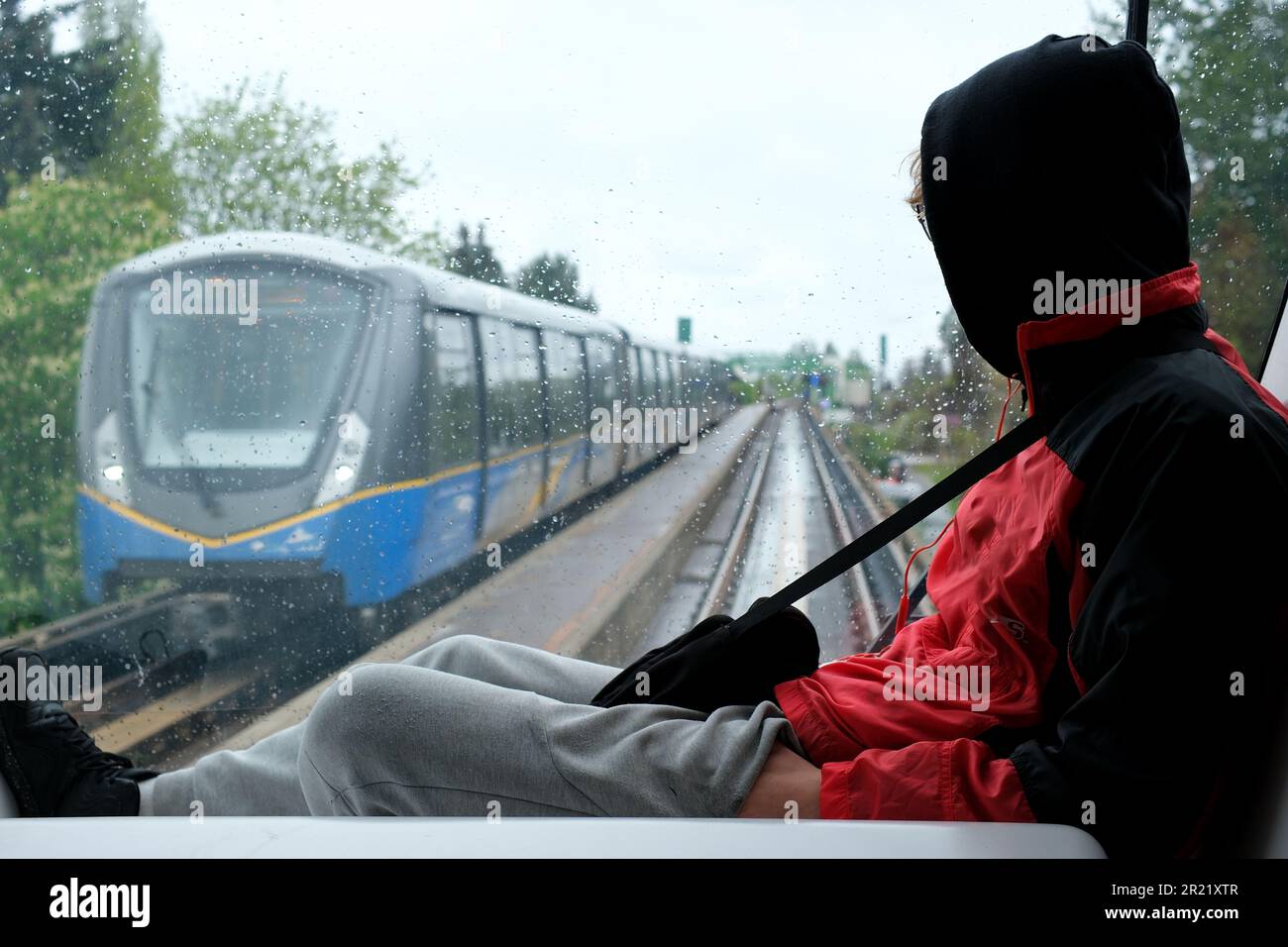 Teenager Person sitzt auf der Windschutzscheibe des Skytrain und sieht sich den Zug an. Teenager Lebensfehler von Jugendlichen Verbotener Ort, nicht den Regeln zu folgen eine Strafe, sich schlecht zu benehmen, Entspannungs-Freuden-Traum Stockfoto