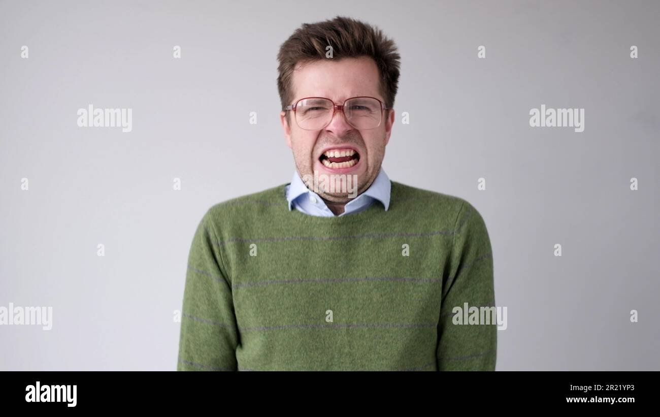 Der europäische junge Mann ist mit dem Ergebnis unzufrieden, er wird wütend und schürt eine grimmige Aggression. Studioaufnahme Stockfoto