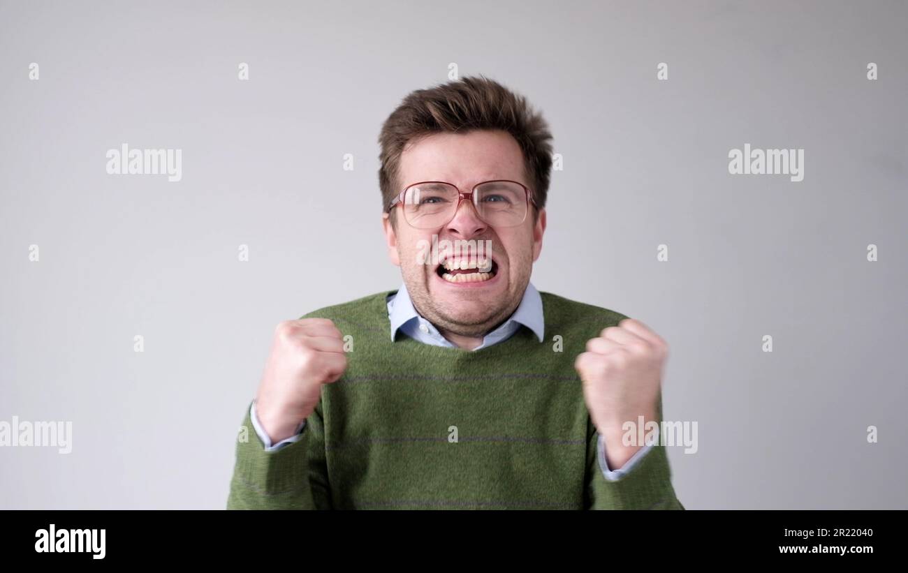 Der europäische junge Mann ist mit dem Ergebnis unzufrieden, er wird wütend und schürt eine grimmige Aggression Stockfoto