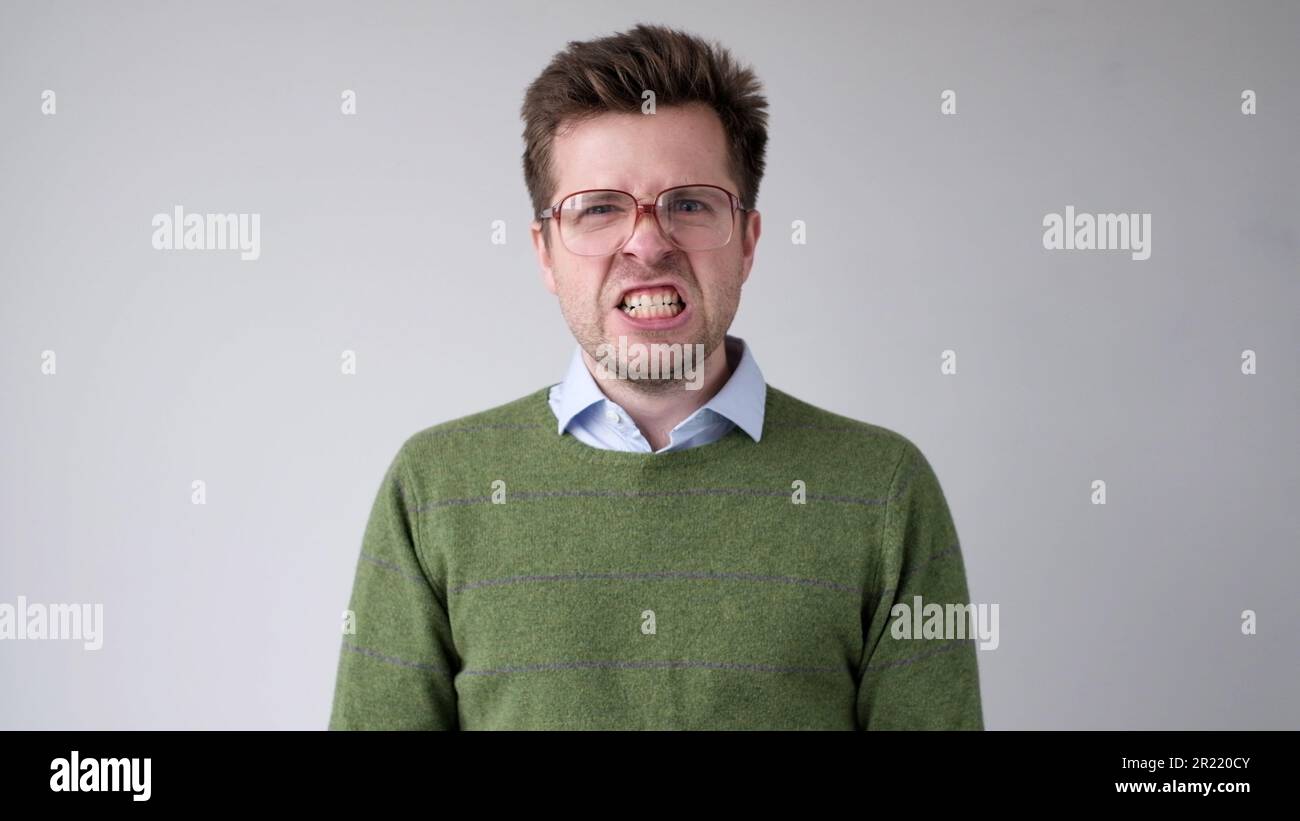 Der europäische junge Mann ist mit dem Ergebnis unzufrieden, er wird wütend und schürt eine grimmige Aggression Stockfoto