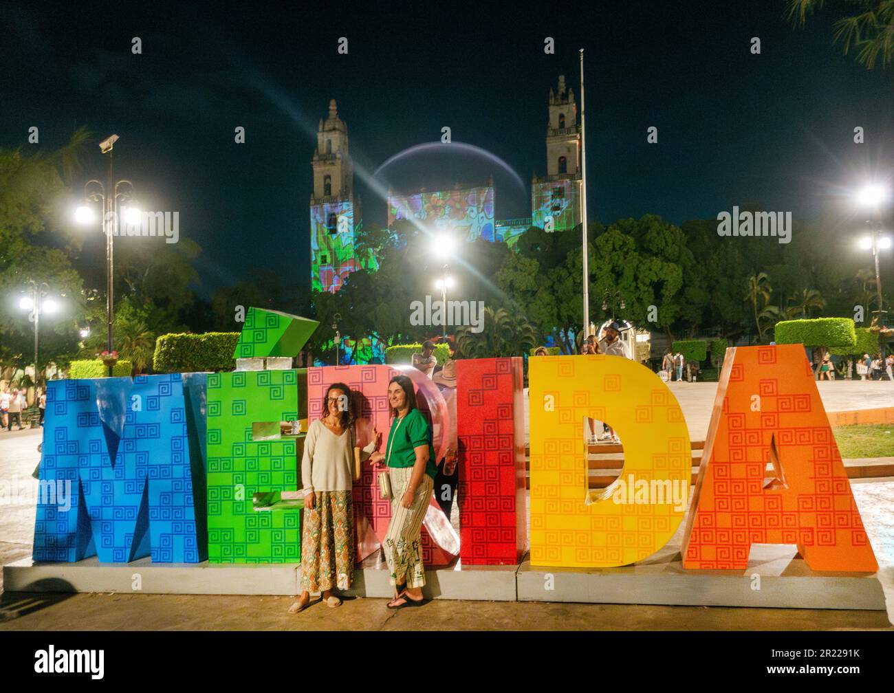 Frauen posieren für ein Foto vor dem MERIDA-Schild vor der Kathedrale von Merida San Ildefonso Yucatan Mexico Stockfoto