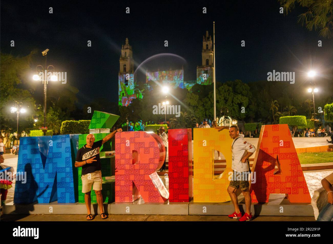 Männer posieren für ein Foto vor dem MERIDA-Schild vor der Kathedrale von Merida San Ildefonso Yucatan Mexico Stockfoto