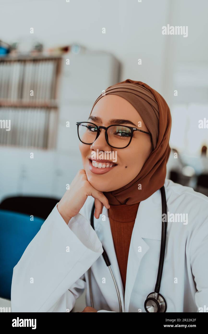 In einem modernen Konferenzraum führt eine muslimische Ärztin mit einem Hidschab ein Gespräch mit ihren Kollegen, was die Macht der Vielfalt veranschaulicht Stockfoto