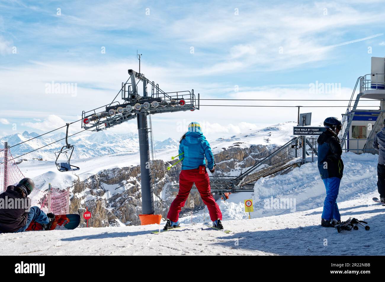 Rette und unterstütze die Skifahrerin, die sich auf den Abstieg vom Gipfel vorbereitet. Personal des Skigebiets in Les Diablerets, Glacier 3000. Stockfoto