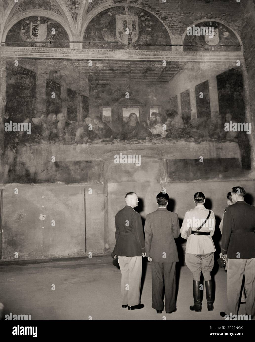 1945 , 25 . juni , MAILAND , ITALIEN : an den letzten Tagen des Zweiten Weltkriegs . Amerikanische und britische Offiziere sehen LEONARDO Da VINCIS Meisterwerk "das letzte Abendmahl " ( L'ULTIMA CENA ) in der Kirche Santa Maria delle Grazie in Mailand . Vom Krieg verschont und unbeschädigt. Wie durch ein Wunder überlebte man einen Bombenanschlag der Alliierten (nur die Mauer mit dem Fresko blieb in den Trümmern unversehrt, während das gesamte Kloster der Madonna delle Grazie zu Boden gerissen wurde). Leonardo da Vincis berühmtes Fresko wird vom britischen Feldmarschall Sir HAROLD R.L.G. bewundert ALEXANDER ( trägt Sam Browne Gürtel - Rupert Leofric George, 189 Stockfoto