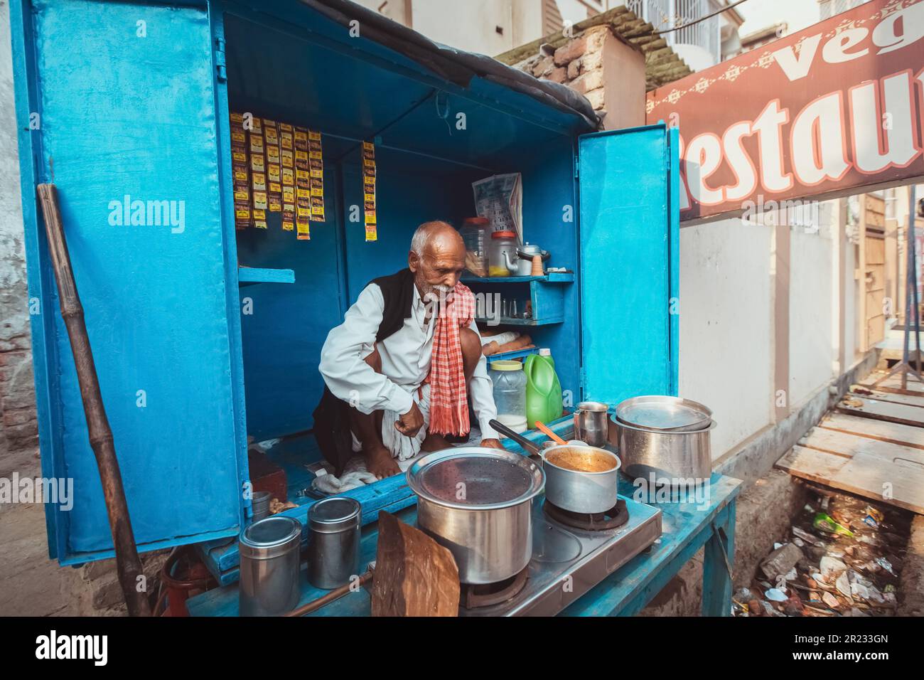 Uttar Pradesh, Indien - 03-15-2017 - einheimischer Mann, der Masala Chai auf der Straße in Varindavan, Uttar Pradesh, Indien zubereitet. Stockfoto