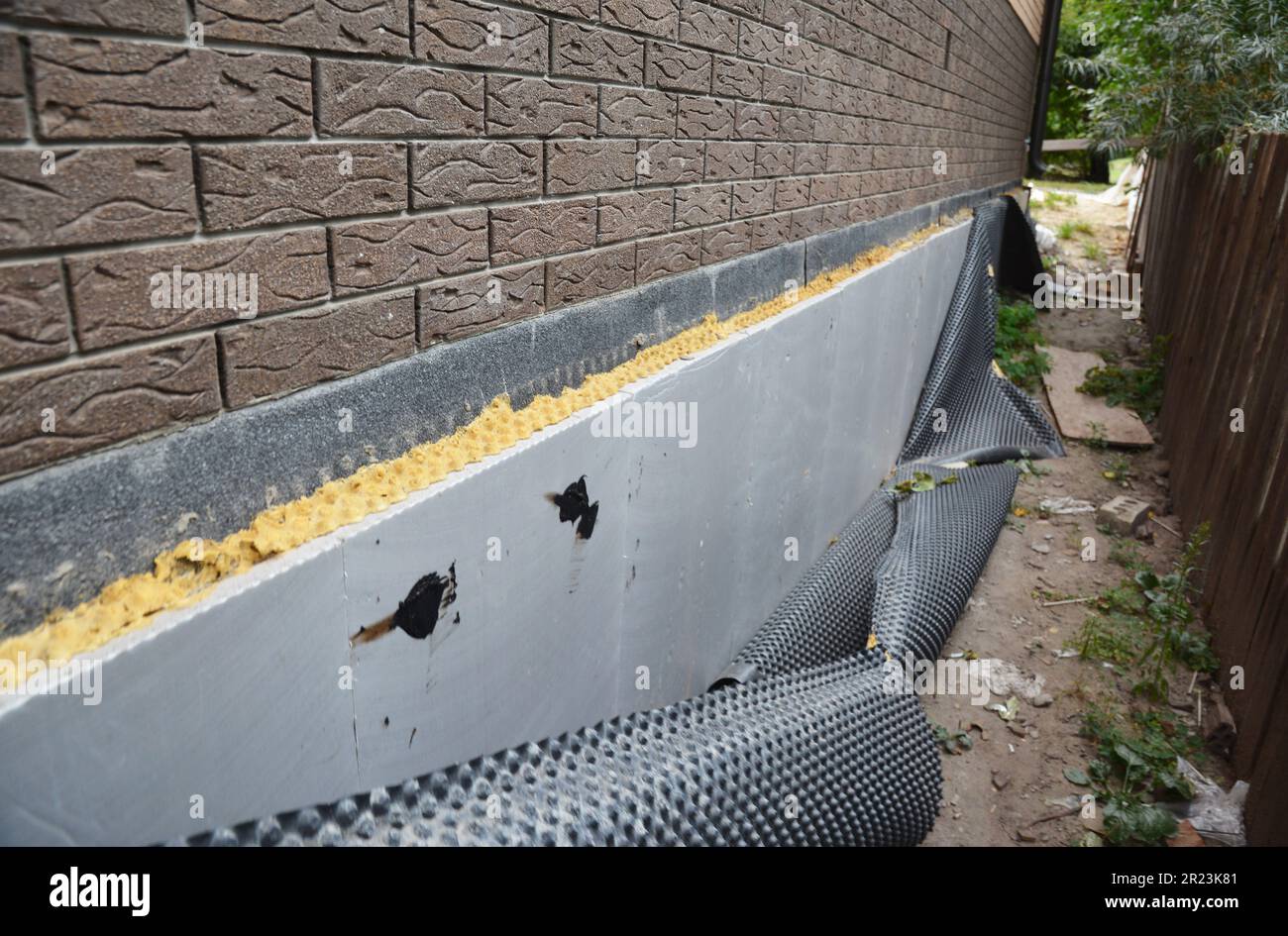 Falsche Abdichtung des isolierten Hausfundamentes. Schlechte Abdichtungsarbeiten und häufige Fehler bei der Abdichtung. Stockfoto