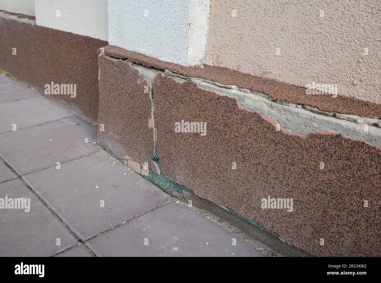 Beschädigter Putz am Sockel und Fundament des Hauses. Dekorativer Putz schützt das Haus vor Feuchtigkeit, Nässe und die Wände vor Zerstörung Stockfoto