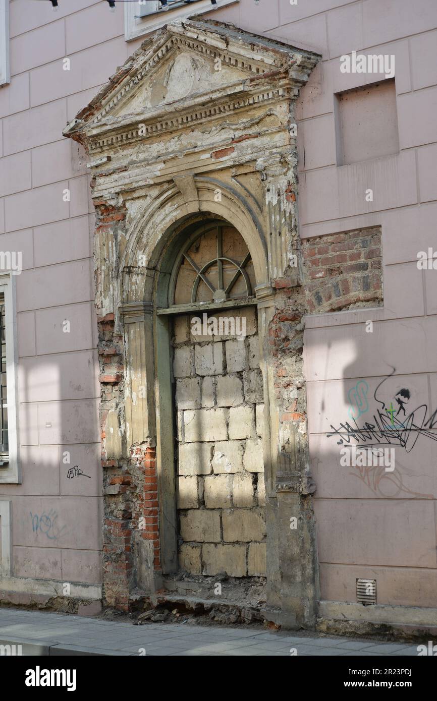 Bruch der alten Tür in einer bedeckten Gebäudewand. Stockfoto