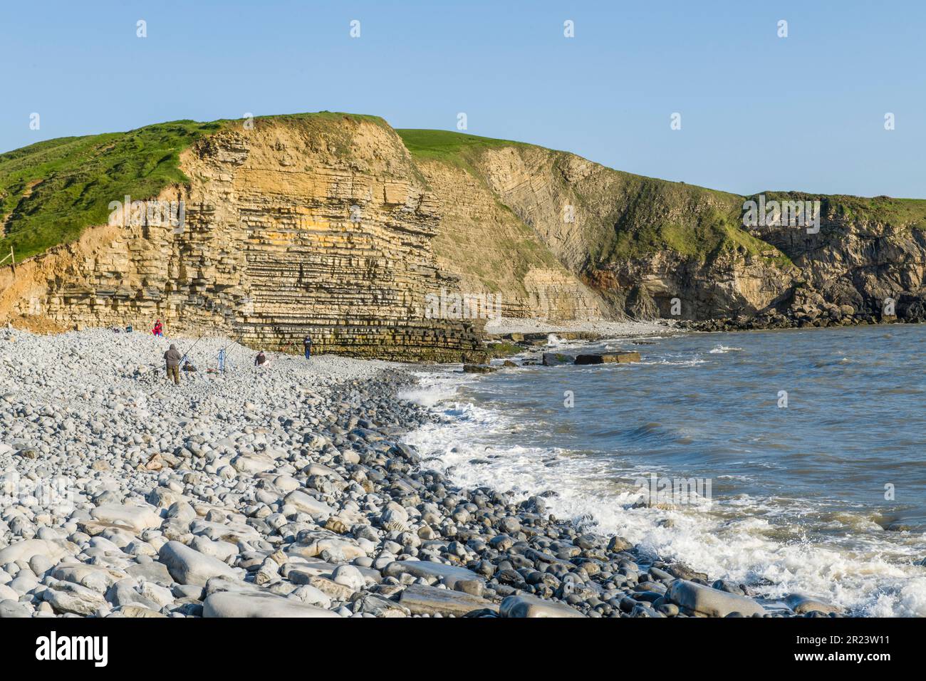 Dunraven Bay, Klippen, Kieselsteine, Sonnenschein und Angler an einem sonnigen Maiabend an der Glamorgan Heritage Coast South Wales Stockfoto