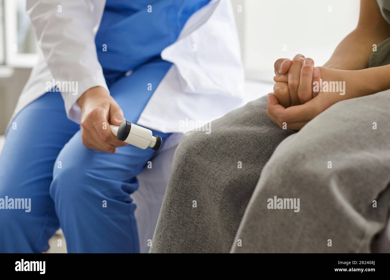 Der Neurologe verwendet einen medizinischen Hammer, um den Kniereflex des Kindes während der medizinischen Untersuchung zu überprüfen Stockfoto