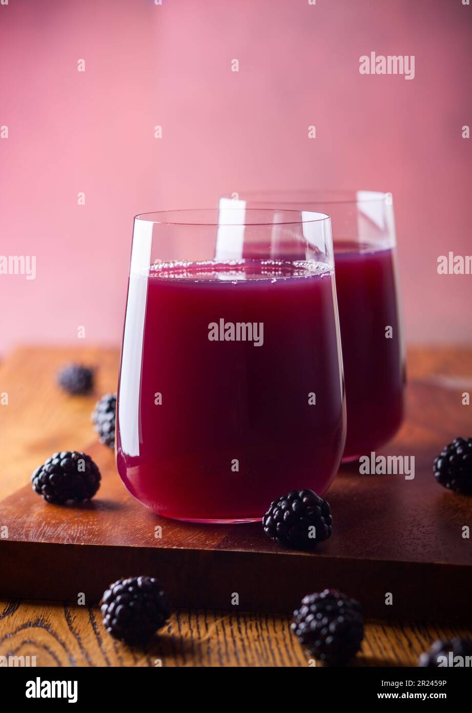 Frischer Brombeersaft in Gläsern mit Minze und frischen Beeren auf dem Holztisch. Stockfoto