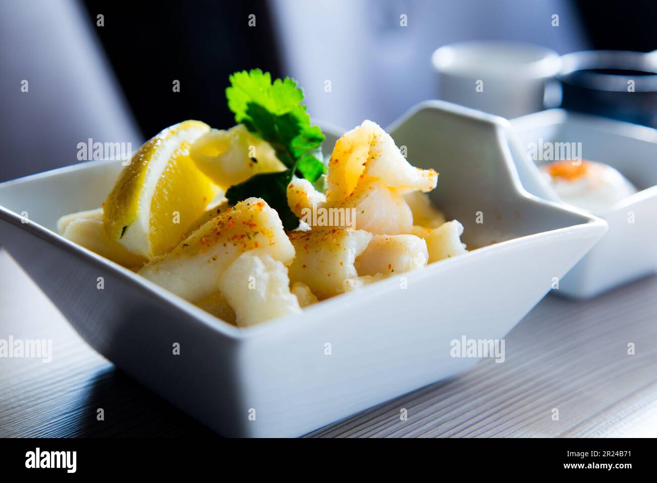 Rabas al ajillo. Rabas mit Knoblauch gekocht. Tintenfischbein-Tapa serviert mit Zitrone. Traditionelle spanische Tapa. Stockfoto