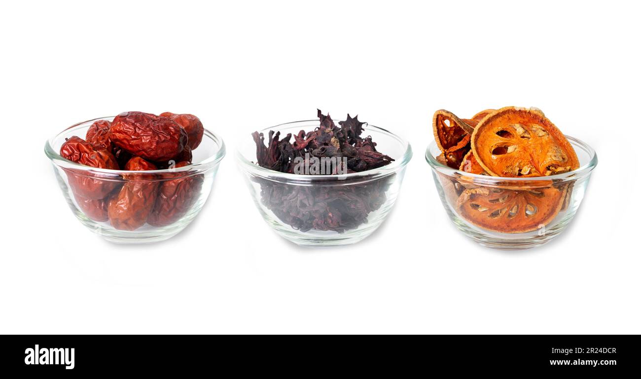 Drei Arten von asiatischen getrockneten Früchten, Bael, Okra und Jujube in Glasschüsseln sind Zutaten für gesunden Kräutertee auf weißem Hintergrund. Stockfoto