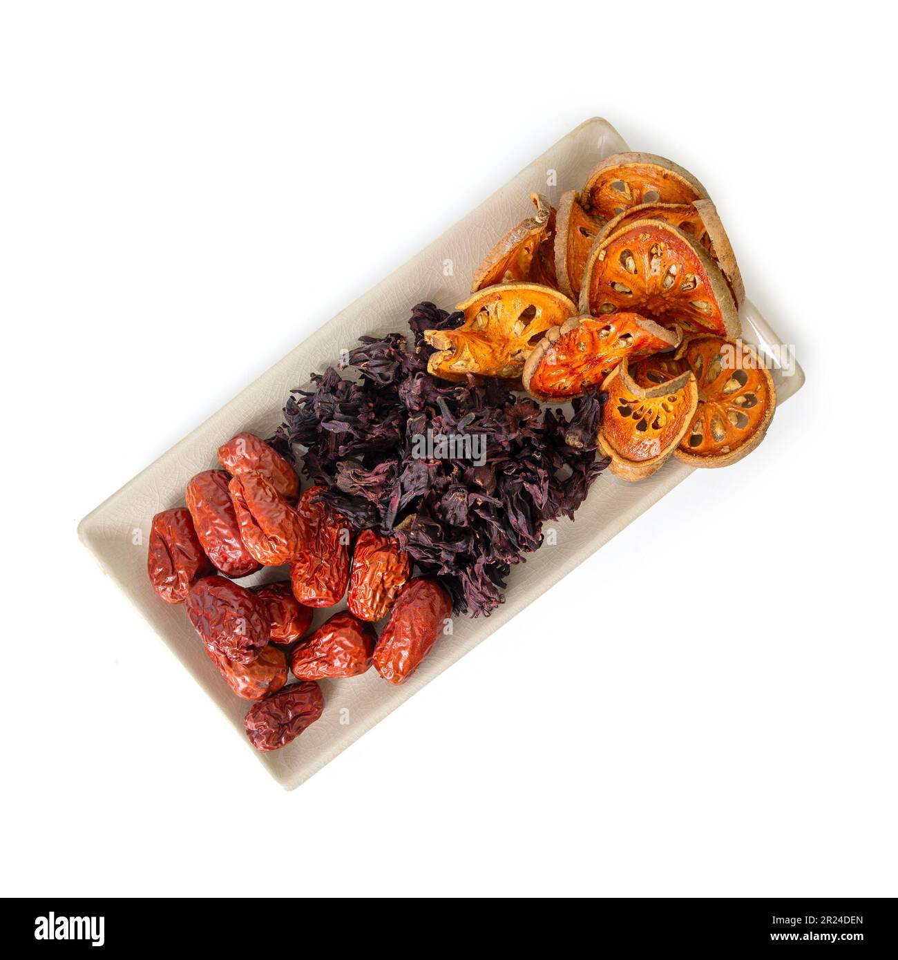 Draufsicht von drei Arten von asiatischen getrockneten Früchten, Bael, Okra und Jujube sind Zutaten von gesundem Kräutertee auf demselben Teller auf weißem Hintergrund. Stockfoto