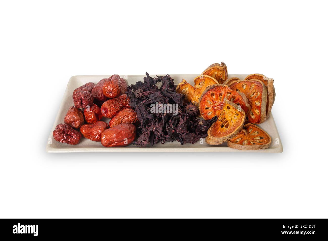 Drei Arten von asiatischen getrockneten Früchten, Bael, Okra und Jujube sind Zutaten für gesunden Kräutertee auf demselben Teller auf weißem Hintergrund. Stockfoto